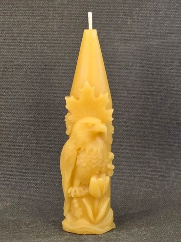 Carved yellow candle with an eagle and floral design.
