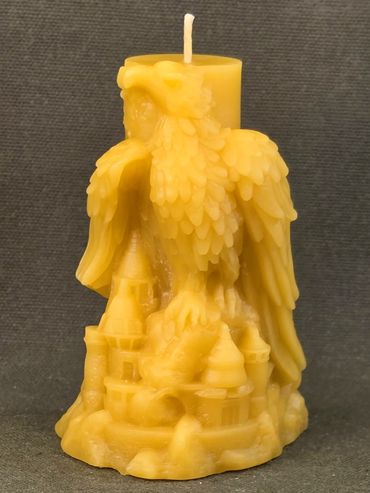 Intricately carved yellow candle featuring an eagle and castle design.