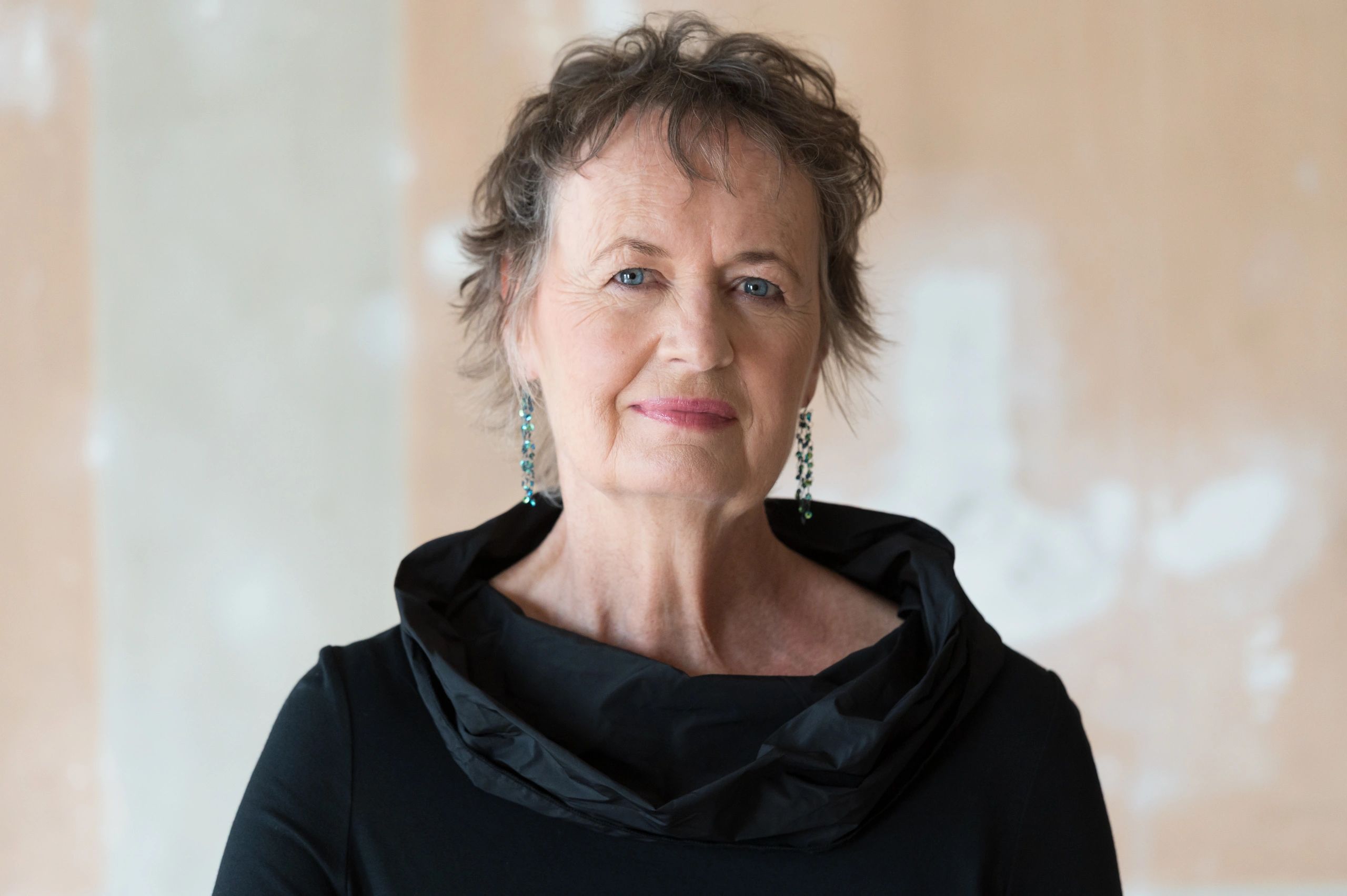 Portrait of an older woman with blue eyes and short curly hair.