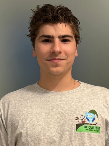 Young man wearing a gray shirt with a lawn care service logo.