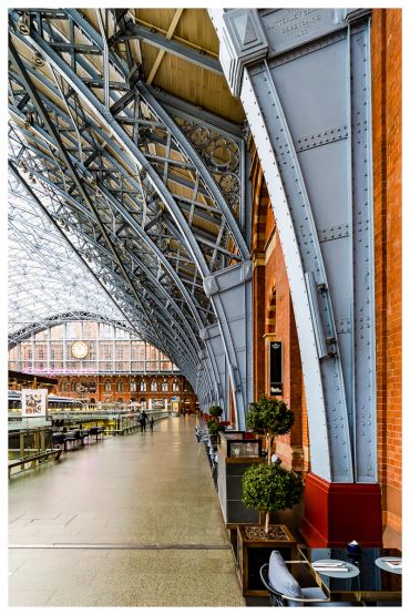 Interior of a historic train station with metal arches.