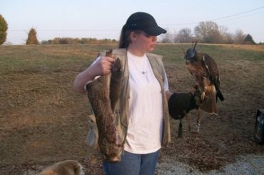 Woman holding large fish and a hawk.