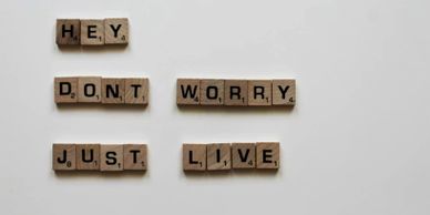Scrabble tiles spell out a positive message: 'Hey, don't worry, just live.'