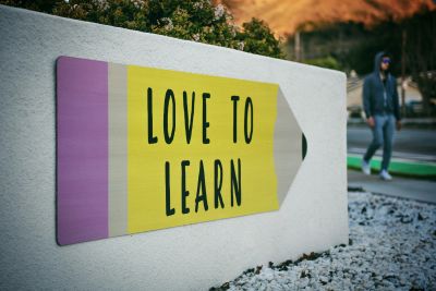 A pencil-shaped sign on a wall reads 'LOVE TO LEARN'.