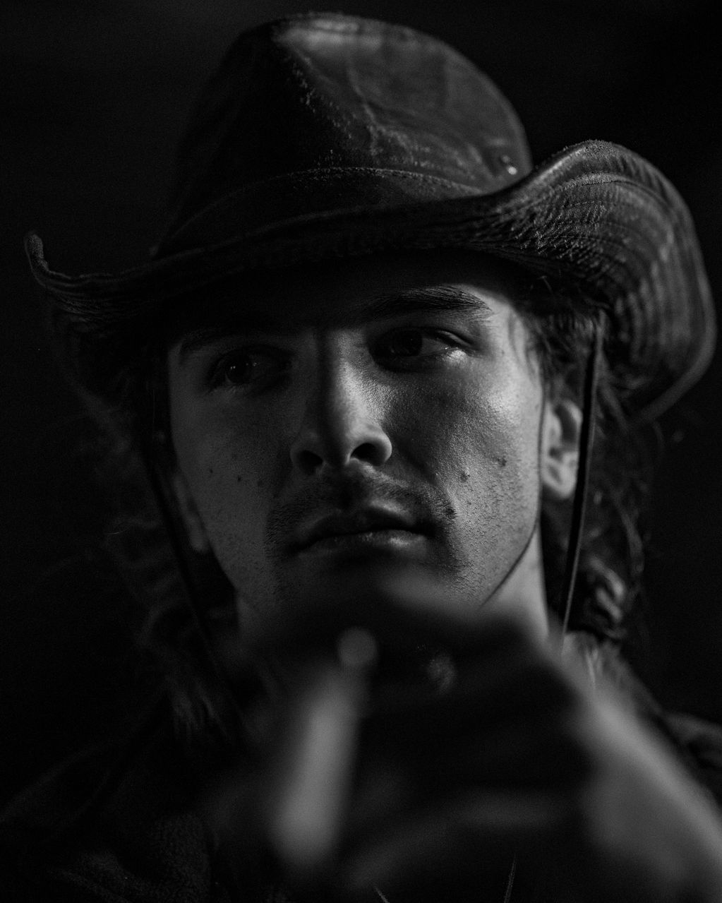 Black and white portrait of a man wearing a cowboy hat.
