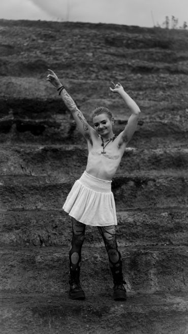 Person posing joyfully on rocky steps.