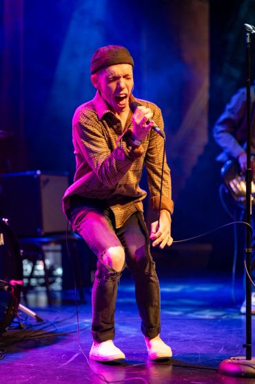 Man passionately singing on stage.