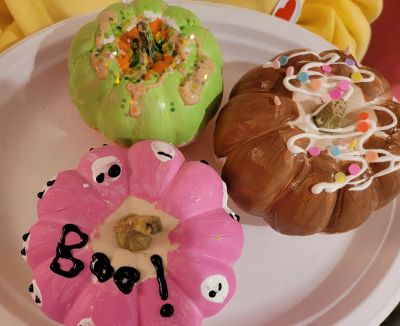 Three decorated pumpkins with colorful paint and designs.