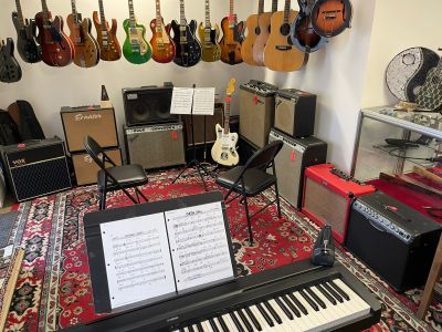 Music room with guitars, keyboard, and amplifiers.