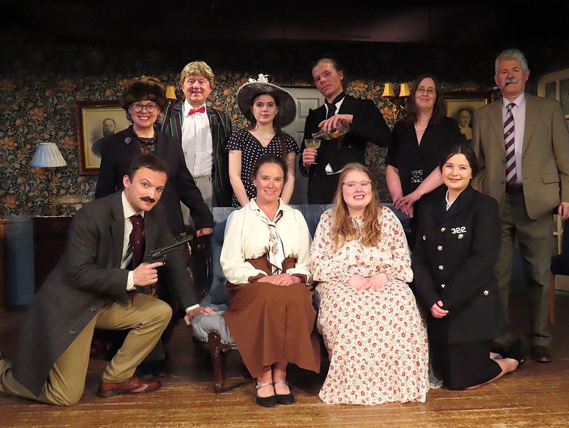 Group portrait of people in vintage costumes, one holding a gun.