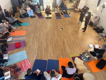 Group sitting in a circle on mats.