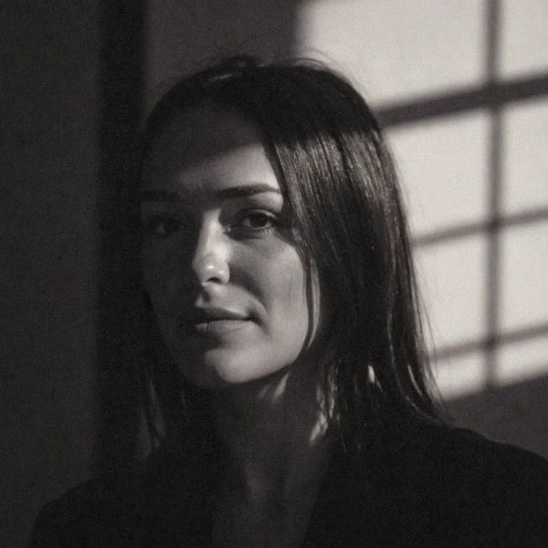 Black and white portrait of a woman with shadow patterns on her face.