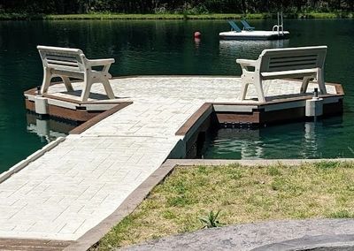 Custom Wave Armor floating dock with seating and swim access installed by AquaLife Construction.