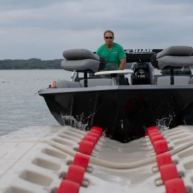 Person driving onto a Wave Armor Boat port surrounded by water on a slightly cloudy day.