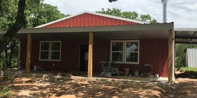 Custom Red Barndominimum with ceder poles on front porch