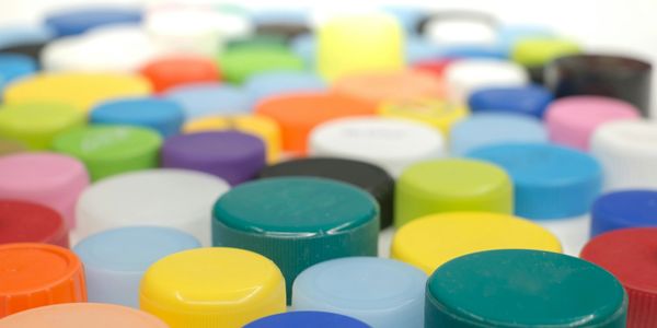 Close-up of various colorful plastic bottle caps arranged closely together.