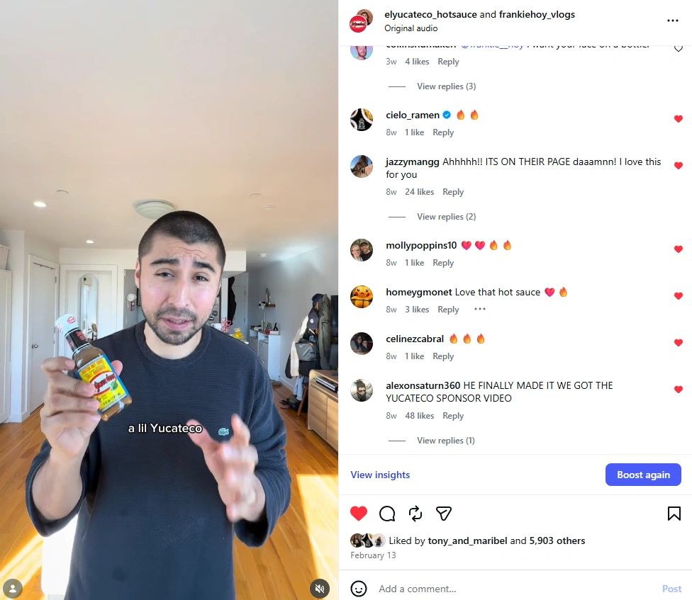 Man holding a bottle of Yucateco hot sauce in a kitchen.