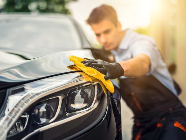 A professional cleaning a car