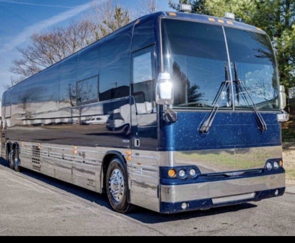 A shiny blue and silver luxury tour bus parked on a street.