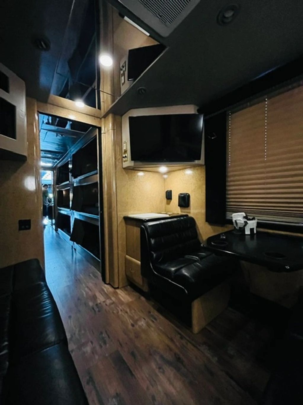 Interior of a modern RV with leather seating and a TV.