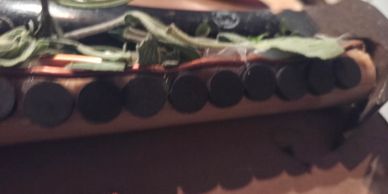 Close-up of a wooden surface with coins and dried leaves.