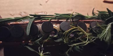 Close-up of a guitar neck with rosemary sprigs laid on top.