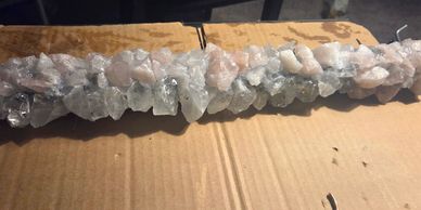 A row of rough, translucent crystals on cardboard.