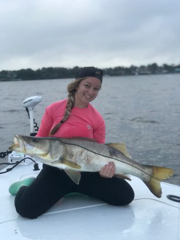 girl holding snook while fishing