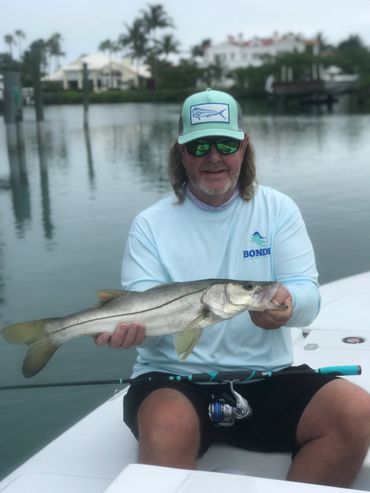 man holding snook and fishing rod