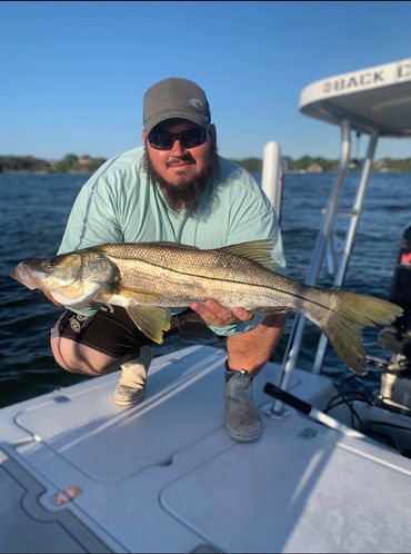 Man holding snook on boat fishing