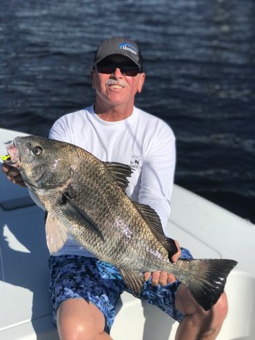 Man holding giant black drum fishing