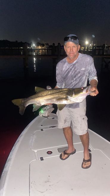 Man holding giant snook night fishing
