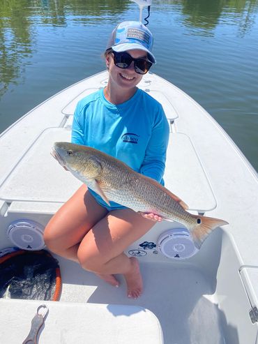 Girl holding redfish on a boat