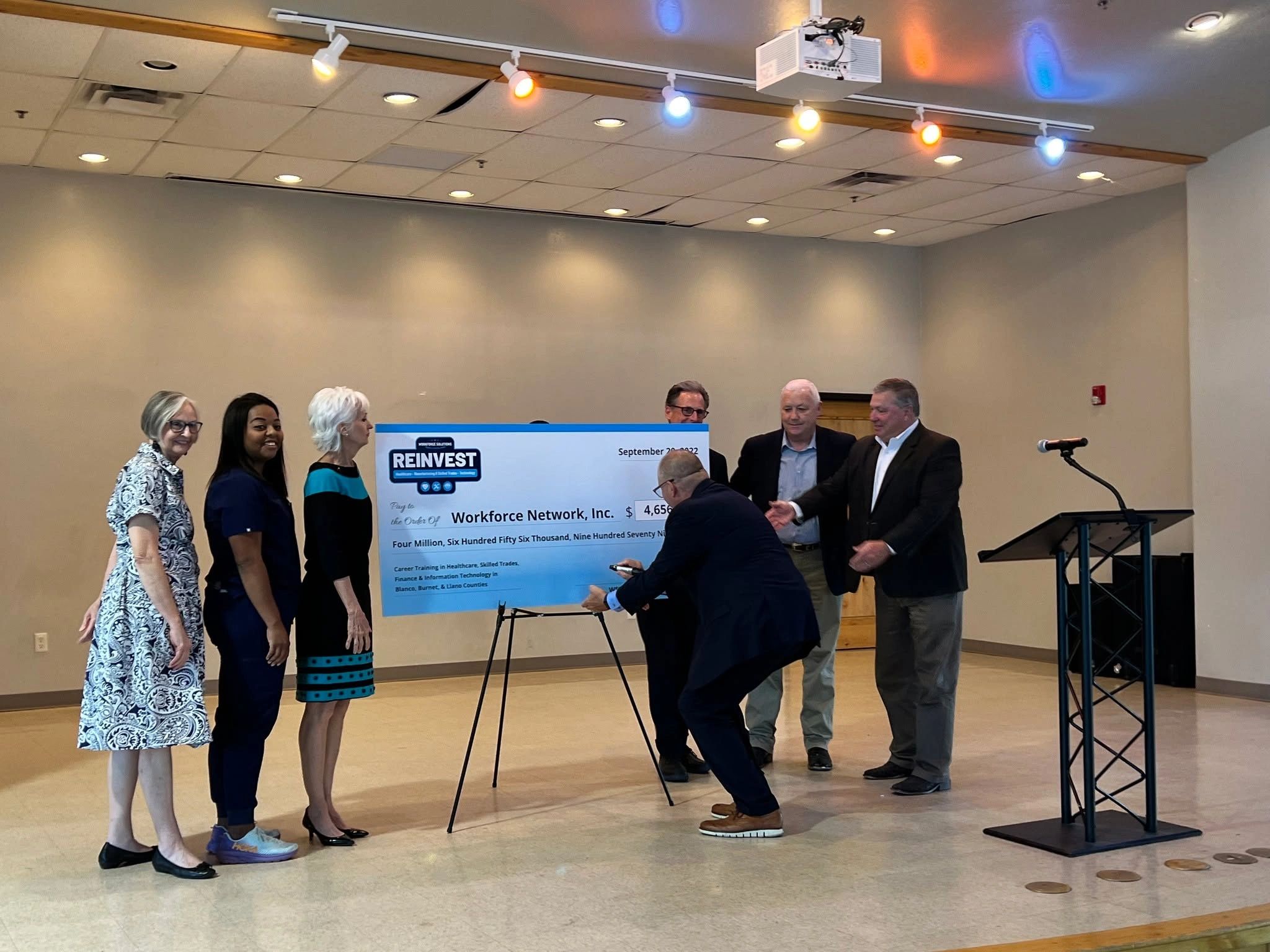 Group holding a giant check for Workforce Network, Inc. funding event.