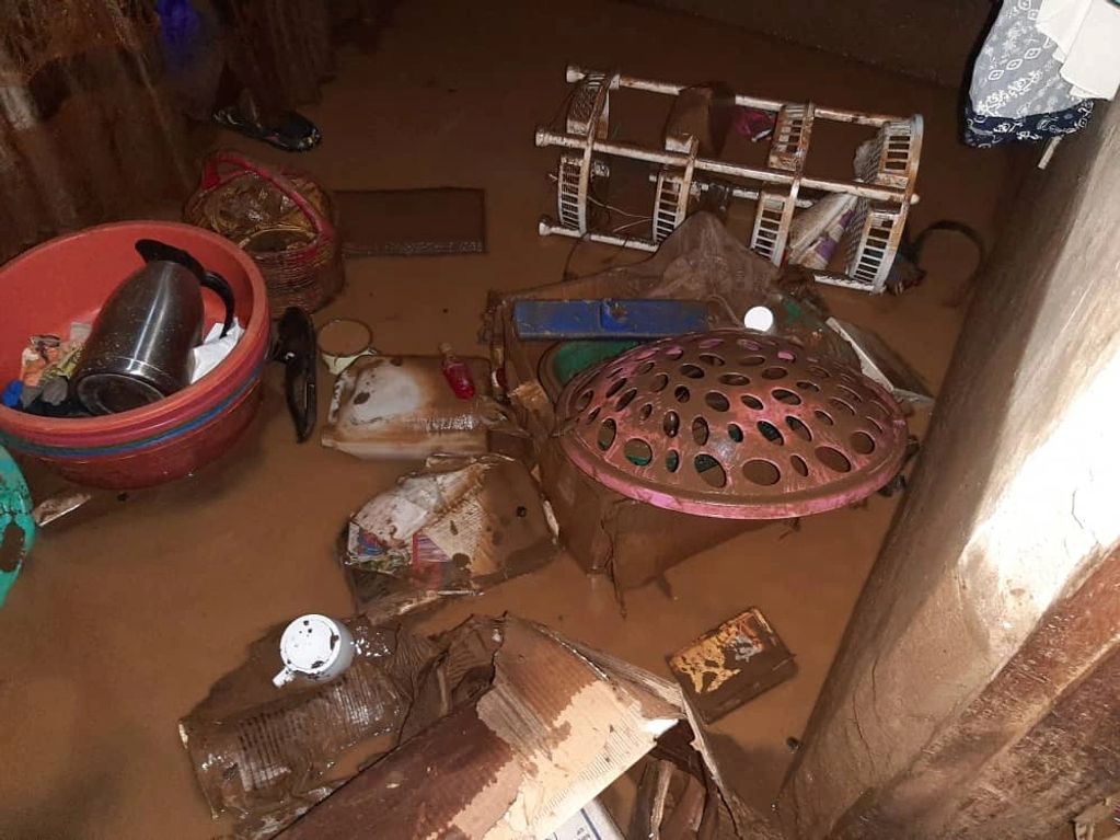 Household items submerged in muddy floodwater inside a home.