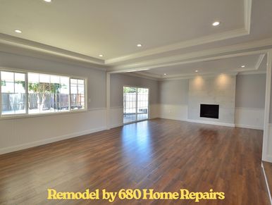 Spacious remodeled living room with wood flooring and fireplace.