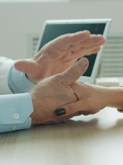 Two people shaking hands across a desk in a professional setting.