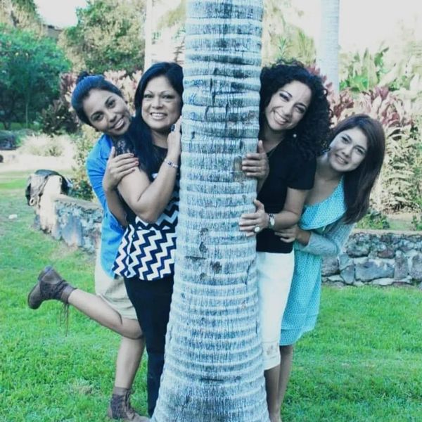 una madre con sus tres hijas sonriendo