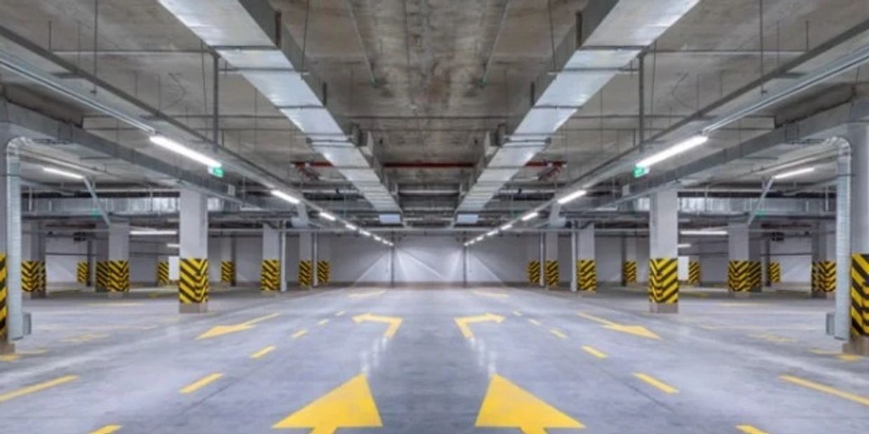Empty indoor parking garage with directional arrows.