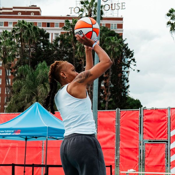 Person preparing to shoot a basketball outdoors.