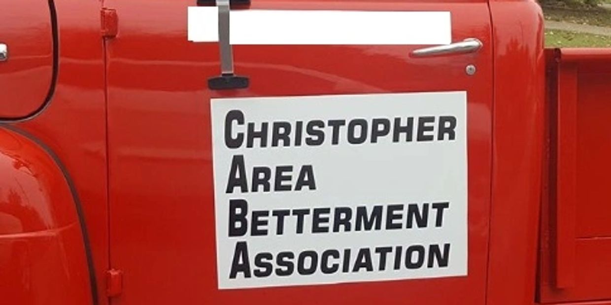 Sign on a red vehicle door for Christopher Area Betterment Association.