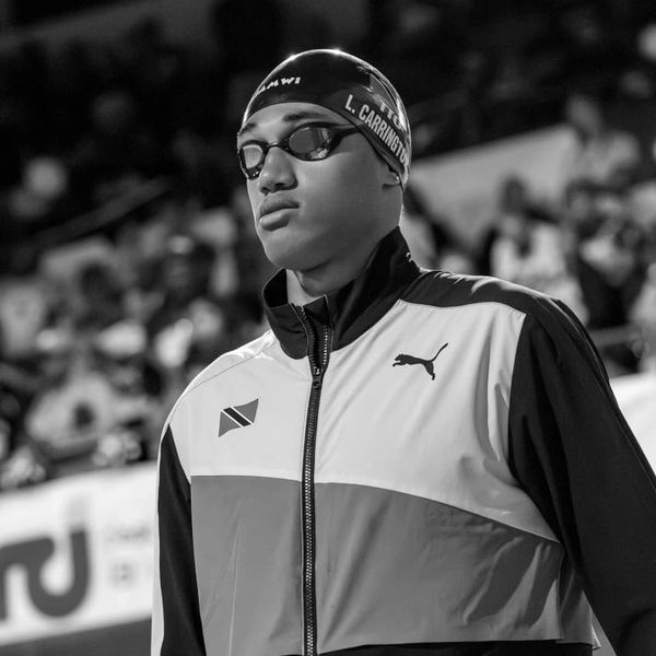 Swimmer in cap and goggles preparing for competition.