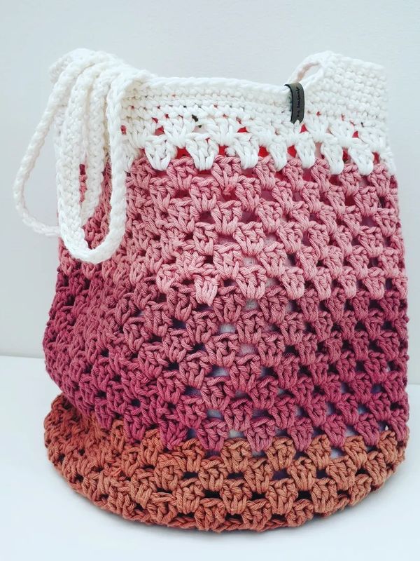 Crocheted bag with gradient colors from white to brown.