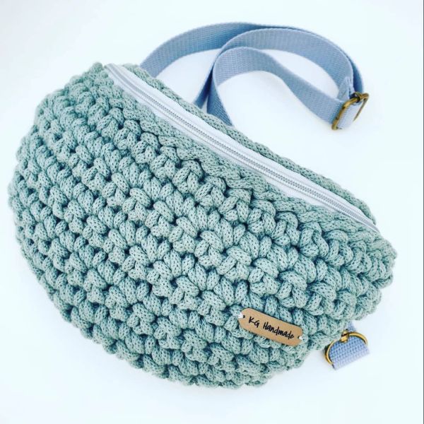 Handmade knitted mint green waist bag with a zipper.