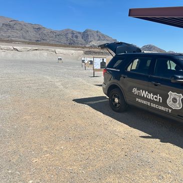 Private security vehicle at a shooting range in a desert area.