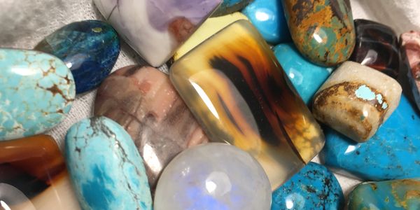 A variety of hand-cut cabochons including turquoise, moss agate, moonstone in different shapes. 