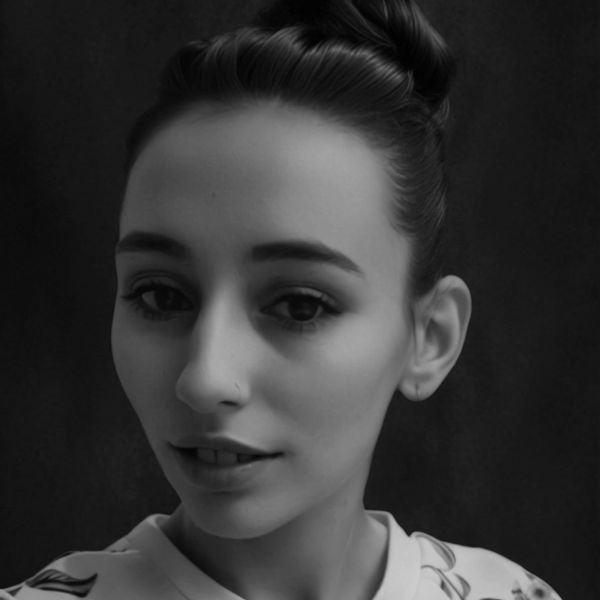 Black and white close-up portrait of a woman with an elegant updo hairstyle.