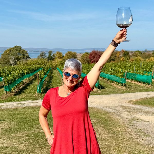 Norma hoisting her Delbrenna magnum wine goblet at a beautiful vineyard.
