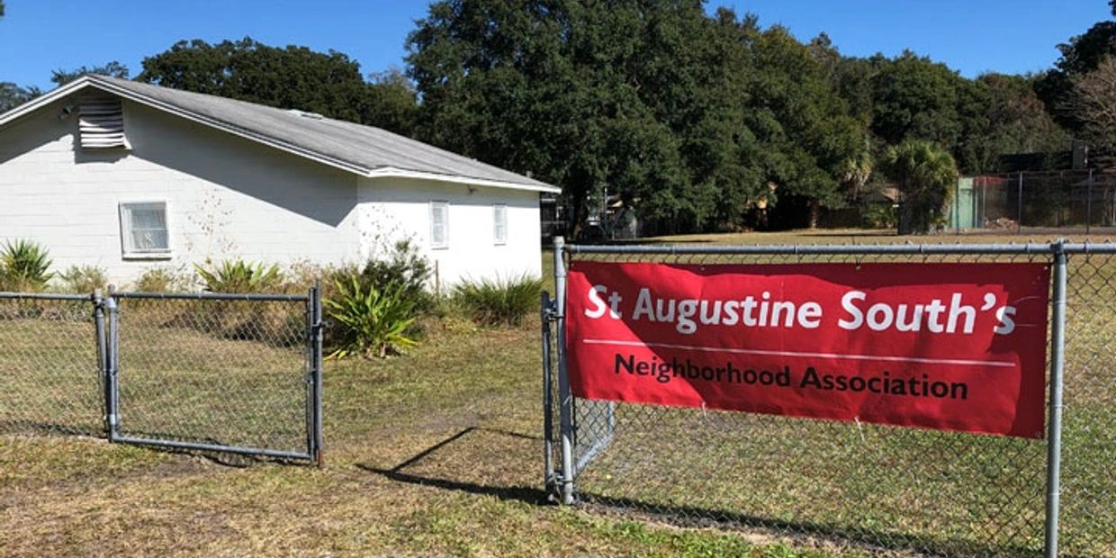 Image of the clubhouse and the gate to the additional parking area