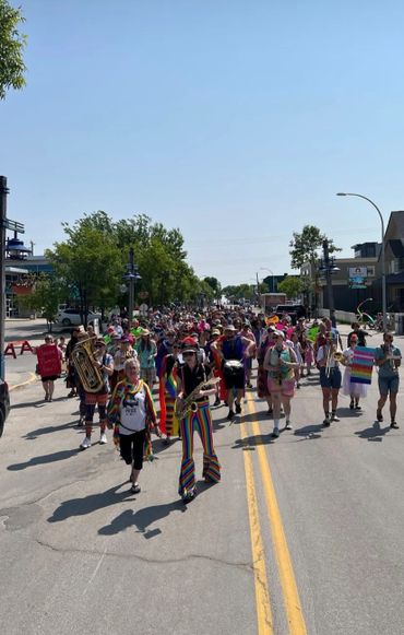 A colorful parade with musicians and participants marching on a sunny street.